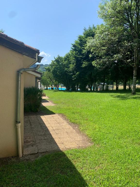 un chemin dans un champ herbeux à côté d'un bâtiment dans l'établissement Le Petit Bois 46, à Leyme