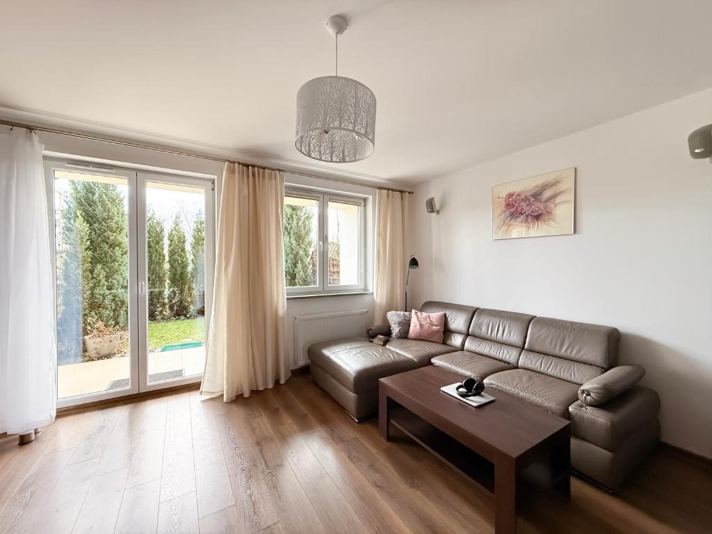salon z kanapą i stołem w obiekcie APARTAMENT POD GWIAZDAMI, z dwoma ogródkami i dwoma tarasami w Polanicy Zdroju
