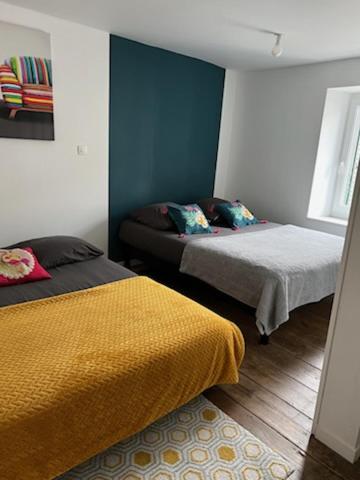 une chambre avec deux lits et une fenêtre dans l'établissement La Flo, à La Flocellière