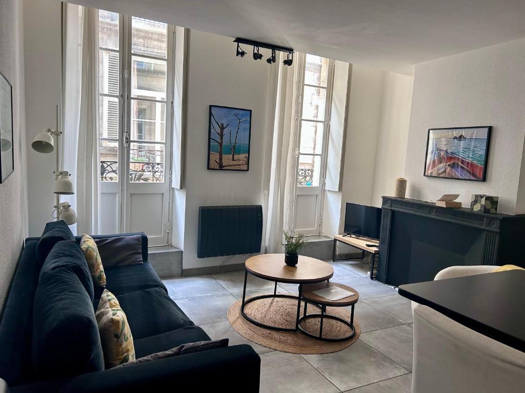 un salon avec un canapé et une table dans l'établissement Appartement cosy avec balcon, centre historique, à Bordeaux