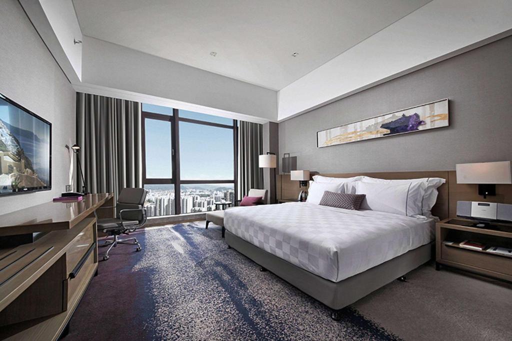 Postel nebo postele na pokoji v ubytování Wyndham JinJiang Hotel