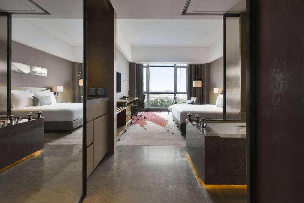 Postel nebo postele na pokoji v ubytování Wyndham JinJiang Hotel