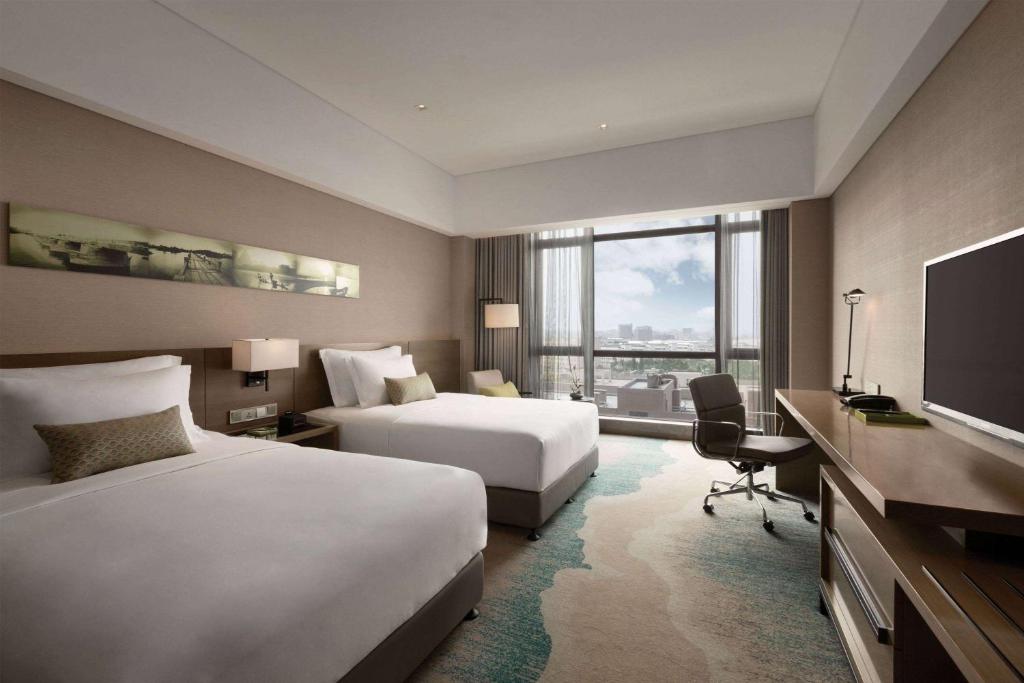 Postel nebo postele na pokoji v ubytování Wyndham JinJiang Hotel