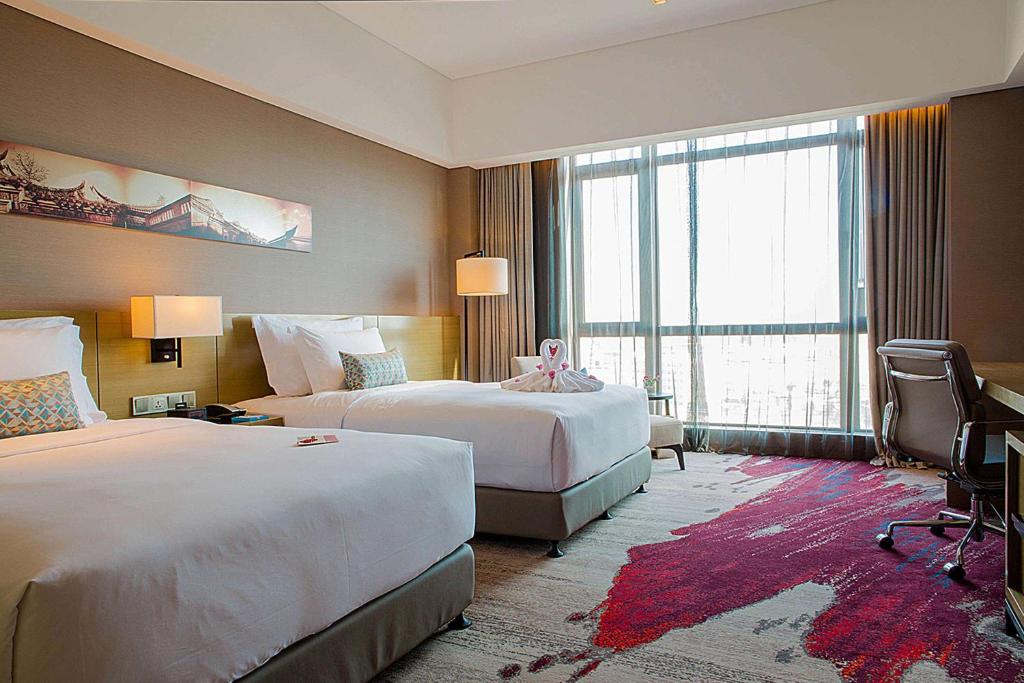 Postel nebo postele na pokoji v ubytování Wyndham JinJiang Hotel