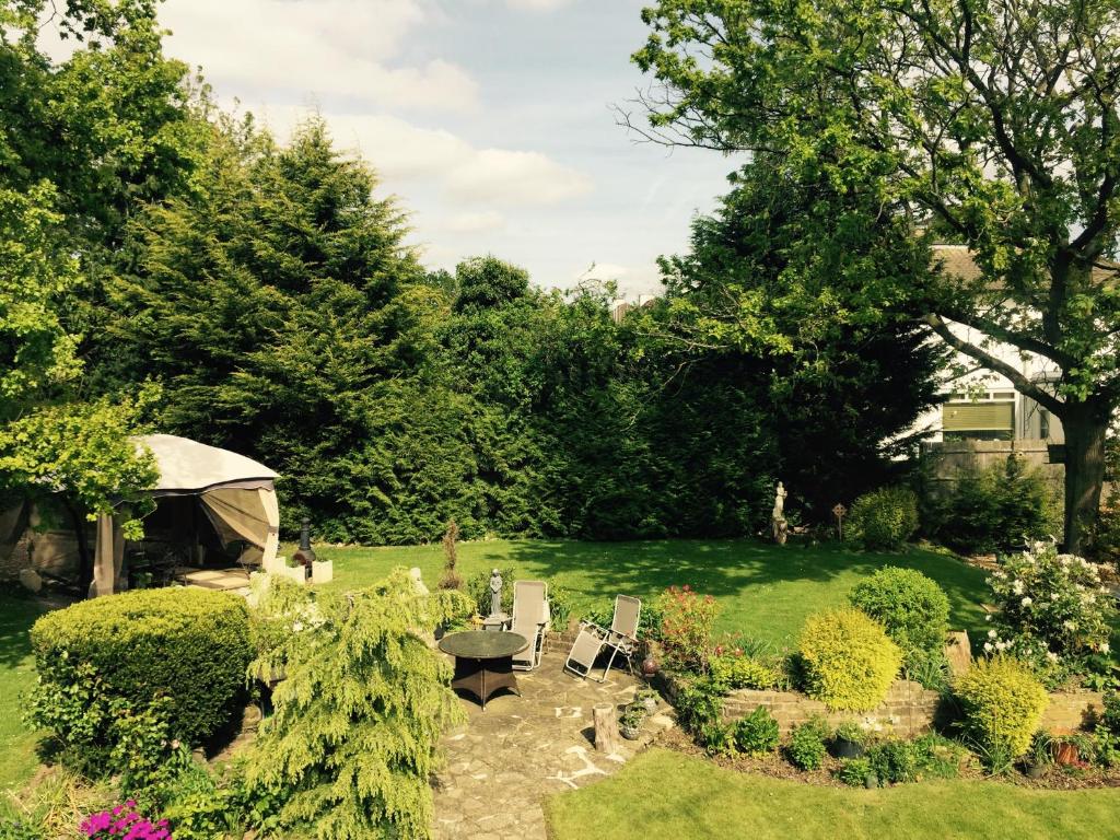 un jardín con mesa y sillas y una tienda de campaña en Edgware B&B, en Barnet