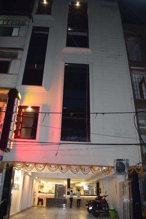 a building with people standing outside of it at night at Hotel Deluxe in Rānchī