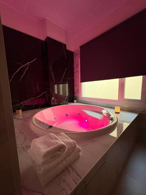 a pink bathroom with a large tub with a pink lighting at Centric Loft near Arts & Science in Valencia
