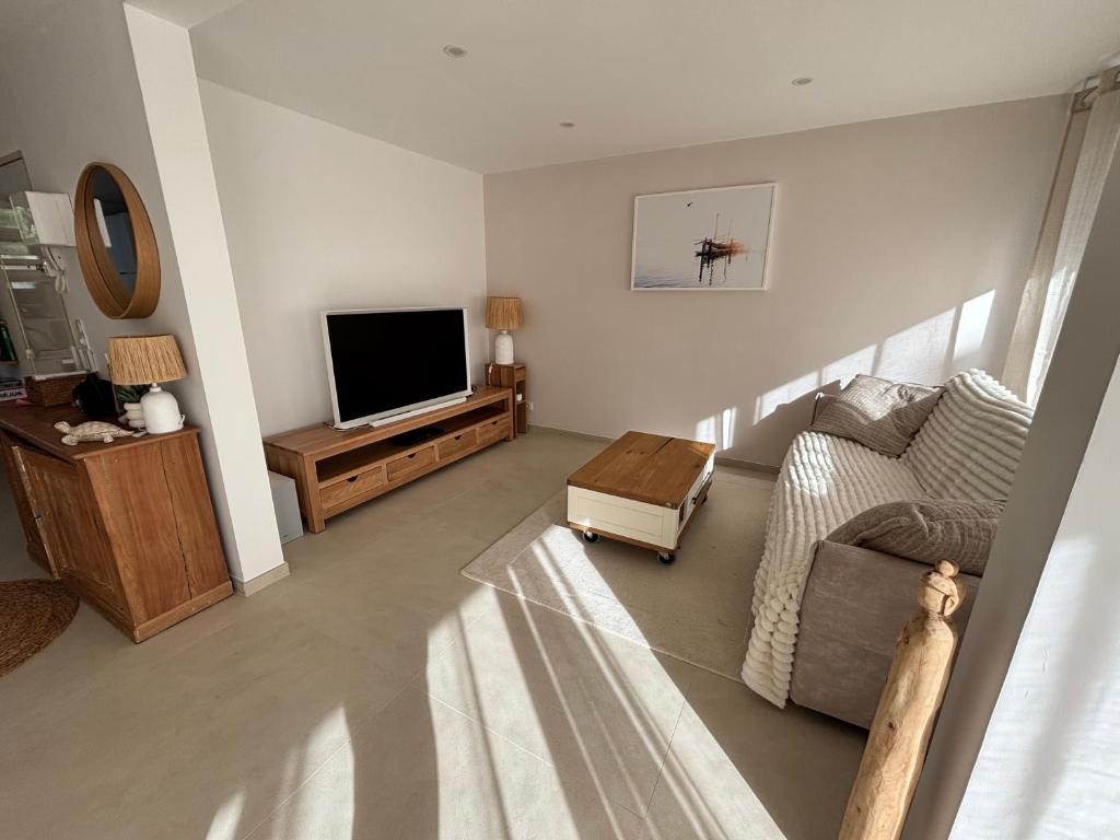 un salon avec un canapé et une télévision dans l'établissement Appartement neuf Fréjus, à Fréjus