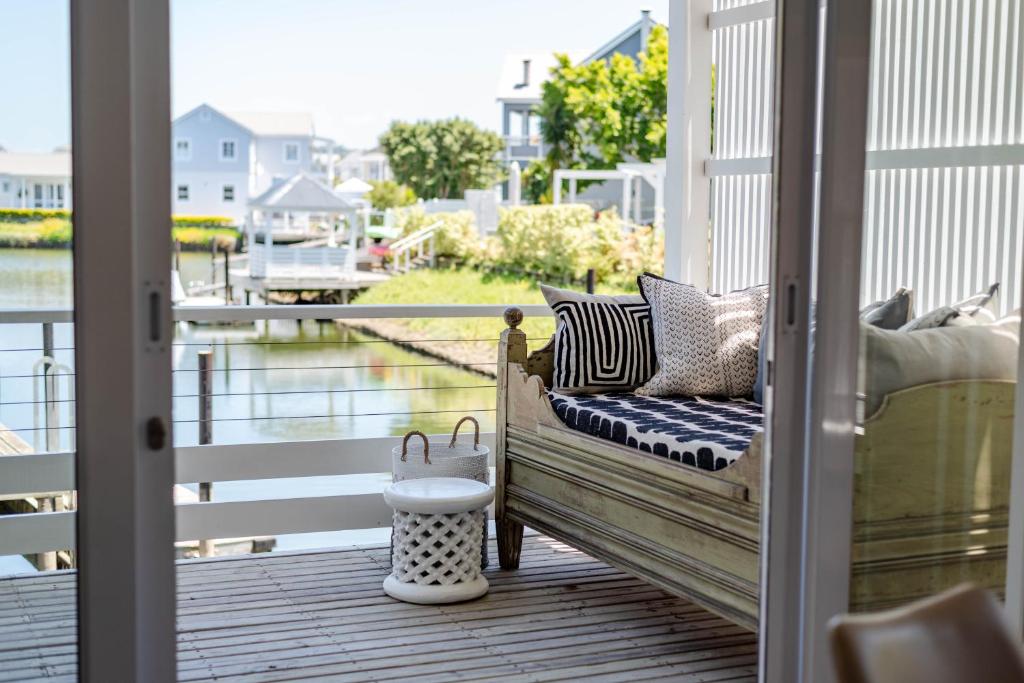 a porch with a bench and a view of the water at Island lifestyle on the water in Knysna