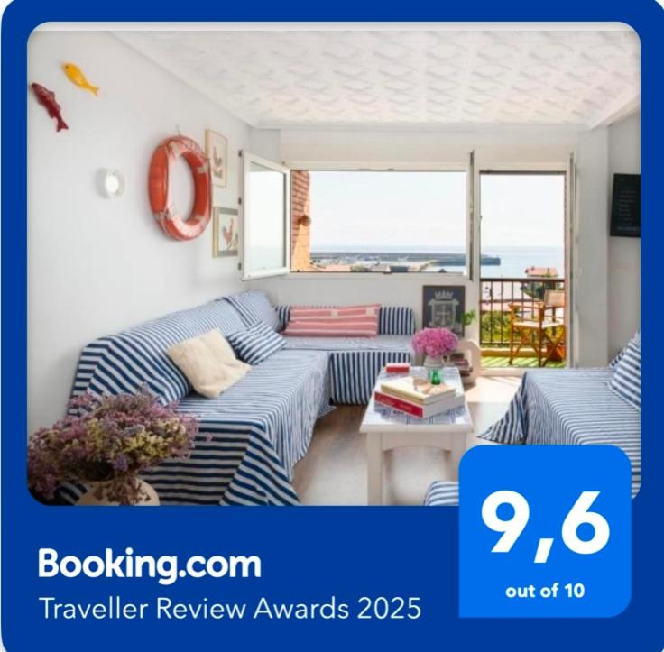 a living room with blue and white striped couches at La Casa del Gallo in Luanco