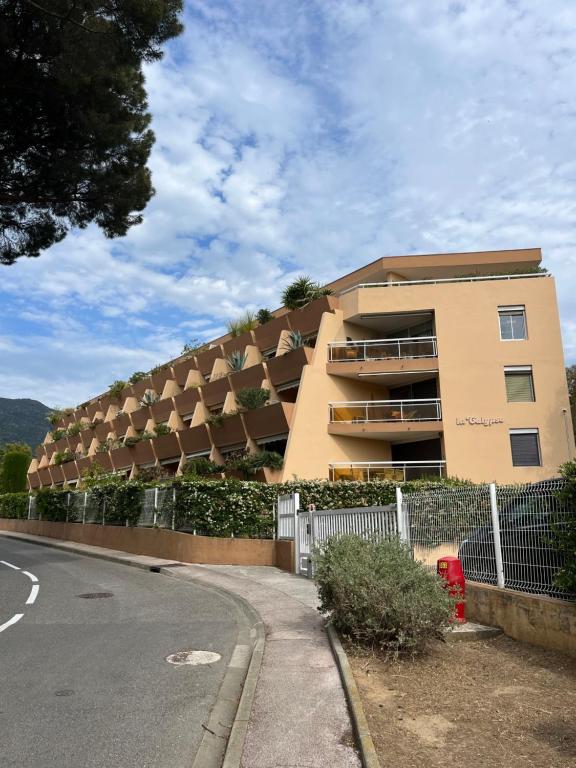 un bâtiment avec une clôture à côté d'une rue dans l'établissement La Calypso, à Cavalaire-sur-Mer
