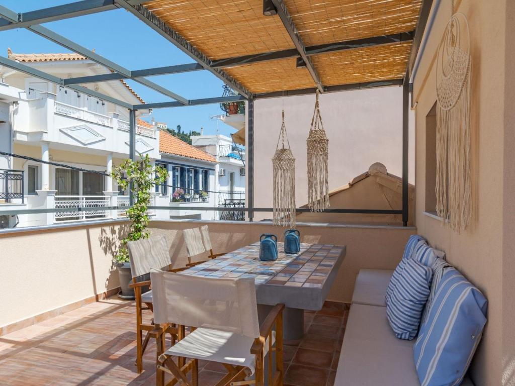 a patio with a table and chairs on a balcony at Elegant City Apartment - 250m from Solomos Square in Zakynthos Town
