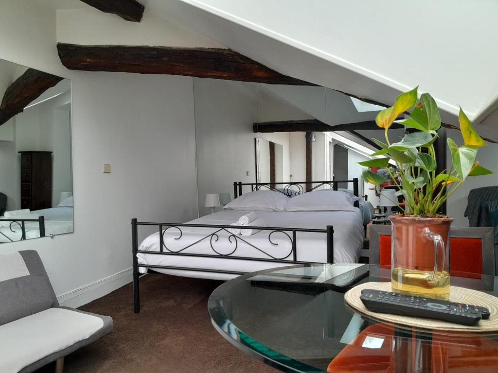 une chambre avec un lit et une table en verre dans l'établissement Le Singulier - Studio au coeur de Paris, à Paris