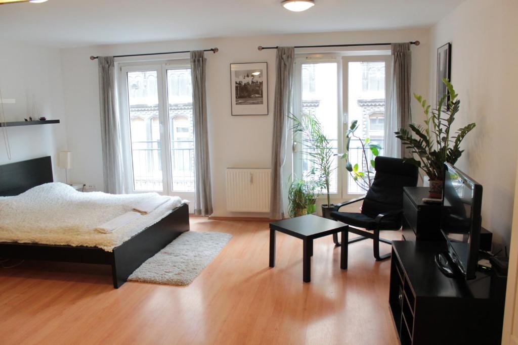 a living room with a bed and a couch and chairs at Erkel Apartment in Budapest