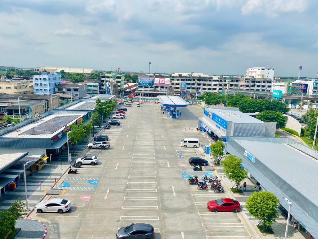 A high-angle view looks over a large open parking area and surrounding commercial buildings.