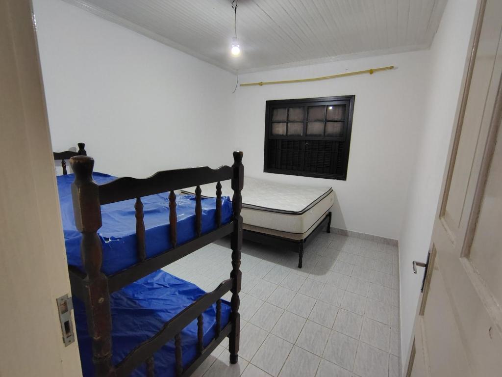 a bedroom with two bunk beds and a window at Casa de Praia - Pe na Areia in Mongaguá