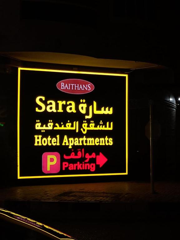 a sign for a hotel apartments parking at Sara Hotel Apartments in Ajman 