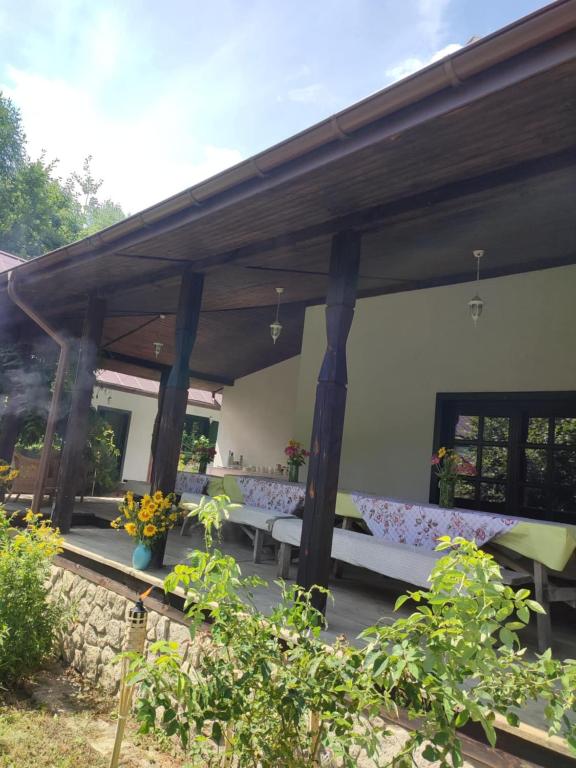 a covered patio with benches and flowers on it at Roztoczańska Posiadłość in Lipsko-Polesie