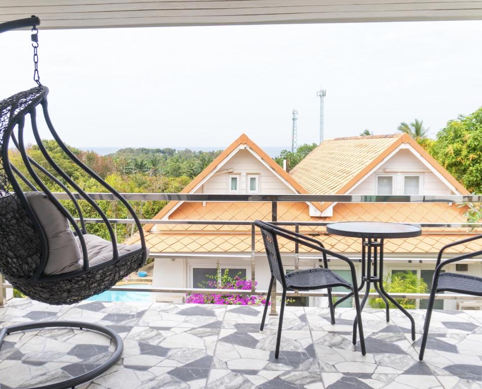 Phra Ae beachにあるLanna Lantaのブランコ付きポーチ、テーブル、椅子