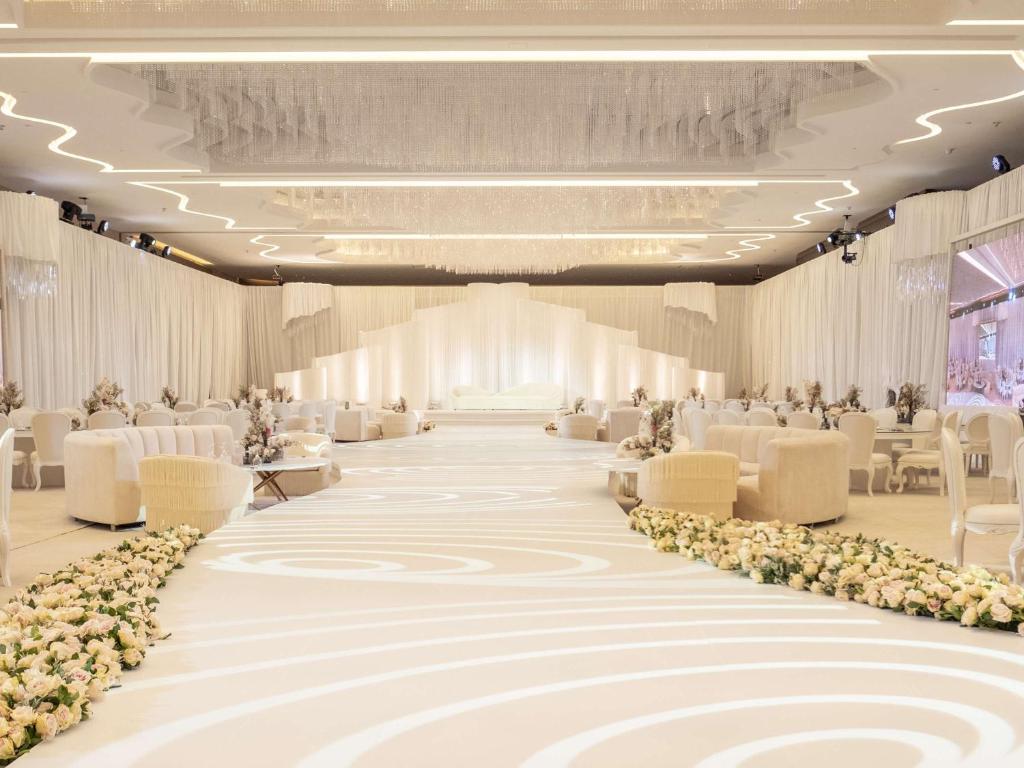 a large banquet hall with white chairs and tables at Pullman Doha West Bay in Doha