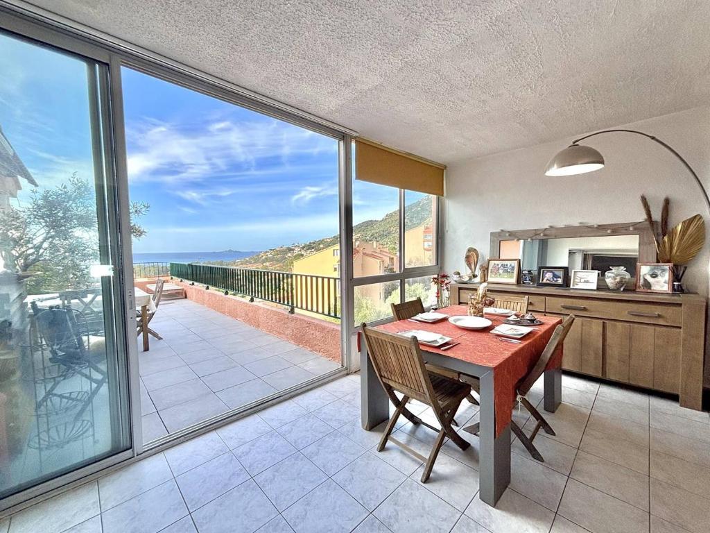 une cuisine et une salle à manger avec une table et un balcon dans l'établissement Appartement vue mer Santa Lina F, à Ajaccio
