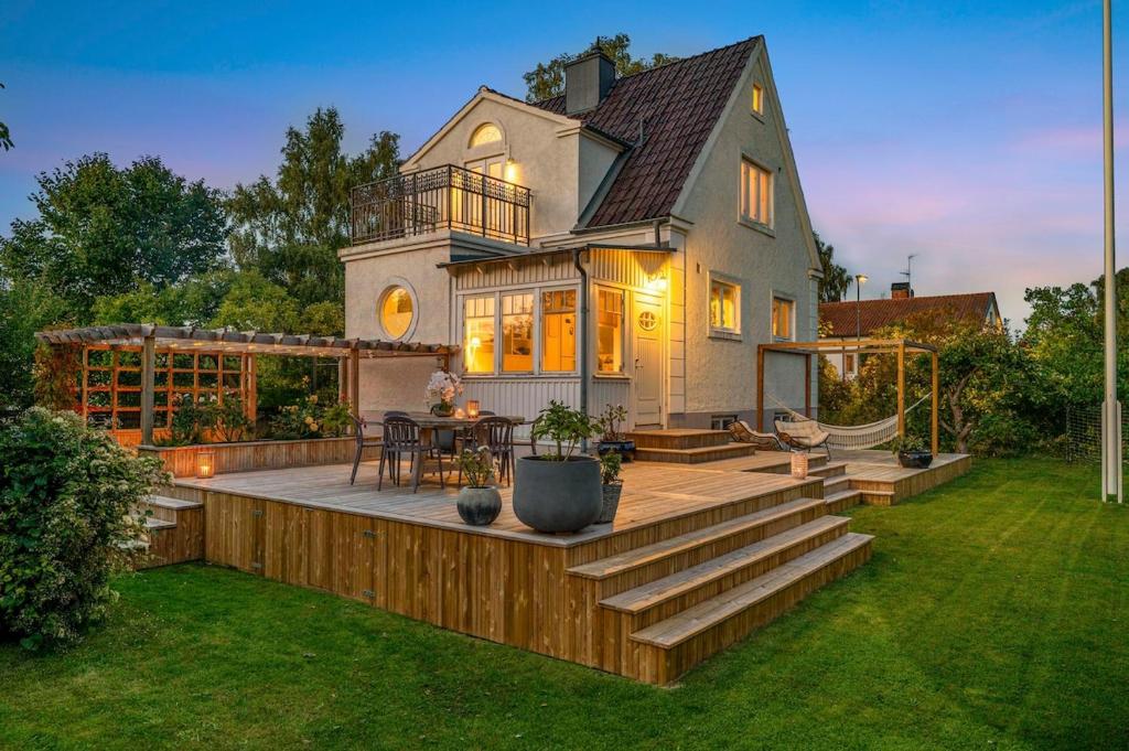 a house with a deck with a table on it at Family-Friendly Retreat Near beach, Malmö & Lund in Åkarp