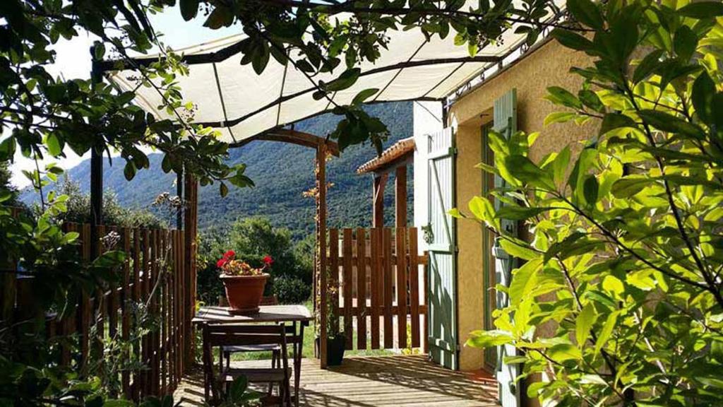 une terrasse couverte avec une table et des chaises. dans l'établissement La Claouzo, à Duilhac-sous-Peyrepertuse