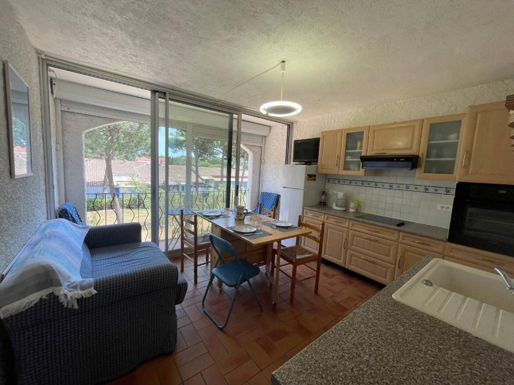 un salon avec un canapé et une cuisine avec une table dans l'établissement Appartement deux pièces cabine- Argelès sur mer AR155-024, à Argelès-sur-Mer