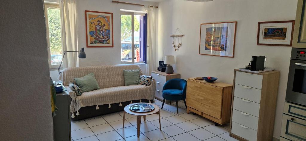 un salon avec un canapé et une chaise dans l'établissement Studio Les pieds dans l 'eau, à Collioure