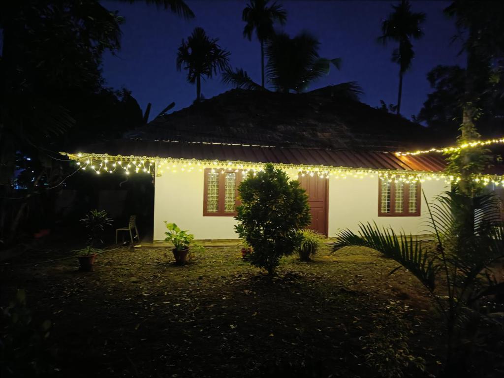 a house with christmas lights on it at night at Bougainvilla Homestay in Alleppey