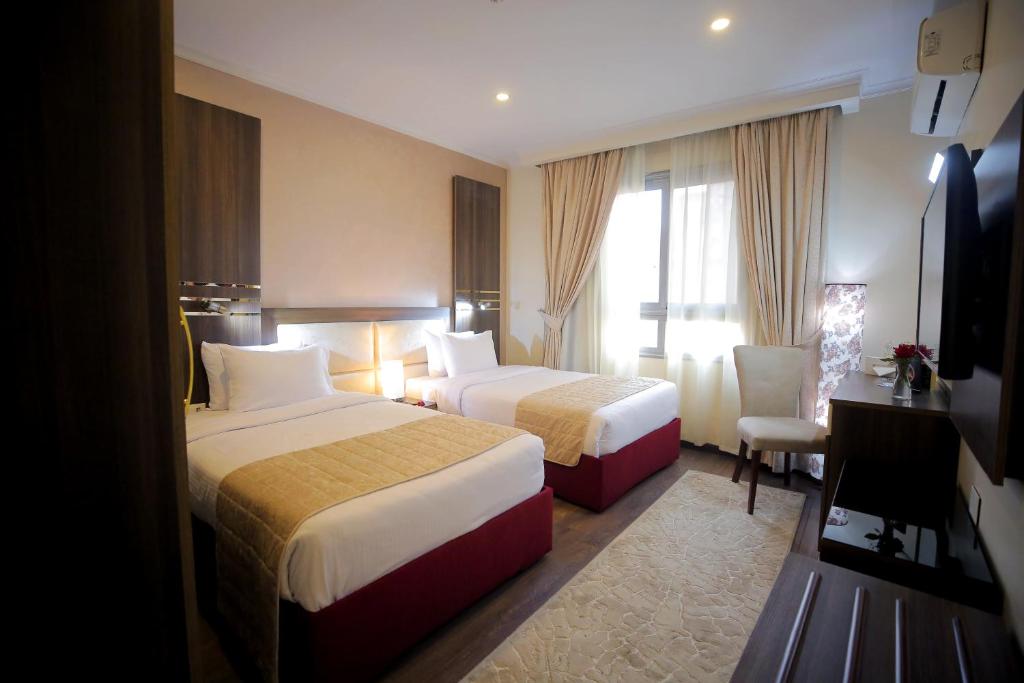 Postel nebo postele na pokoji v ubytování Cairo Taj Hotels & Suites - Dokki