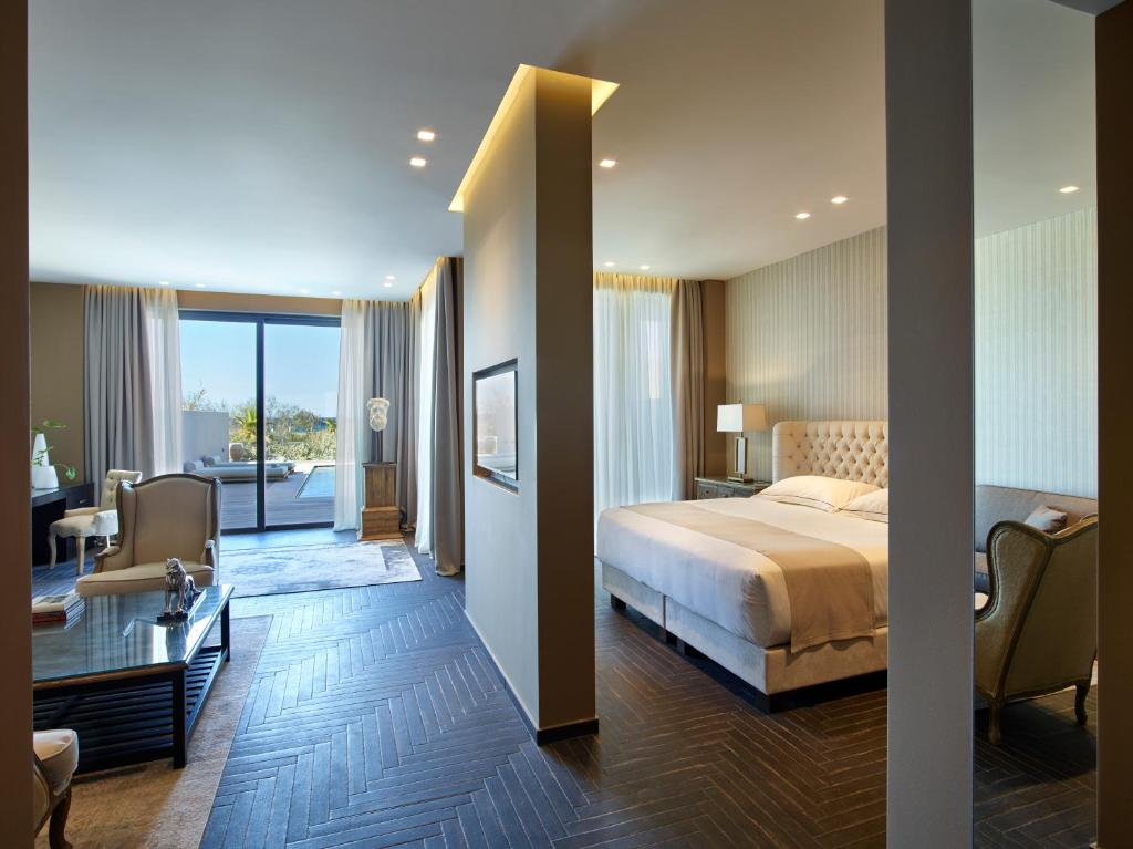 A bed or beds in a room at Pelagos Suites Hotel & Spa