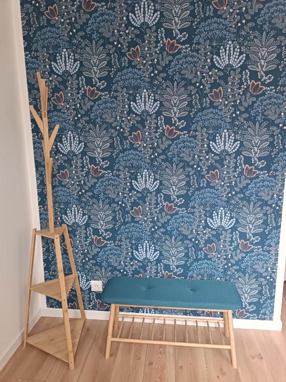 a room with a blue wallpaper with a blue bench at Appartement moderne et bohème in Vittel