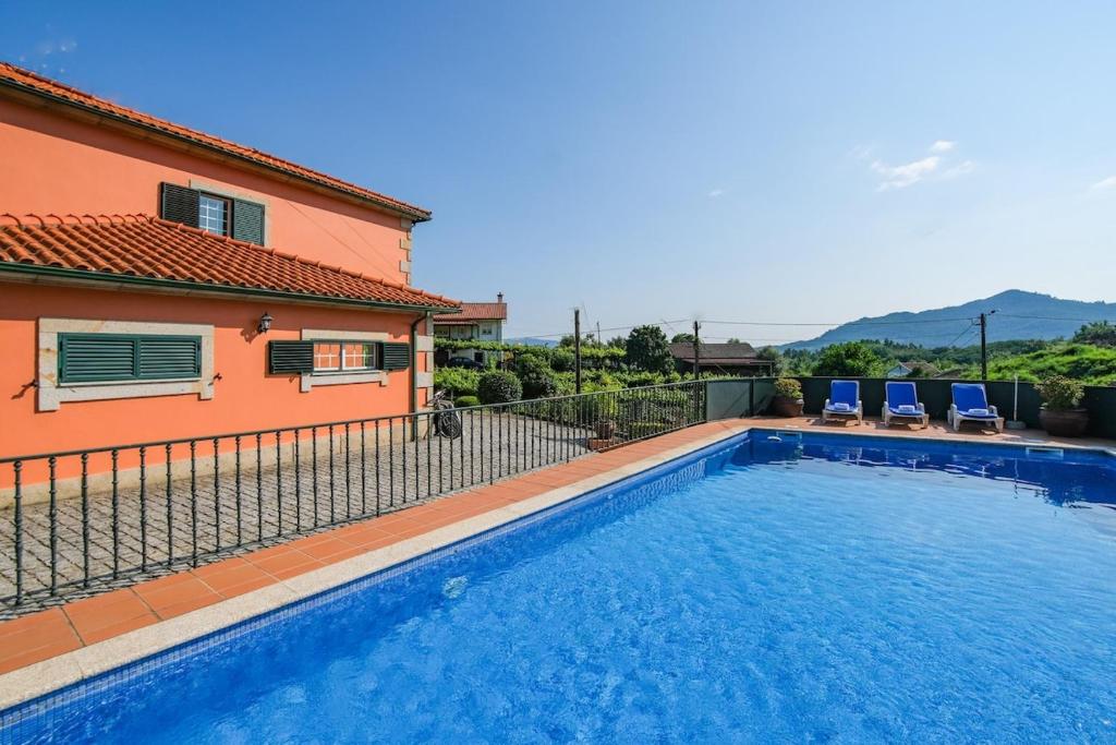 a swimming pool in front of a house at Slow Living Countryside House by Portugal Active in Moreira do Lima