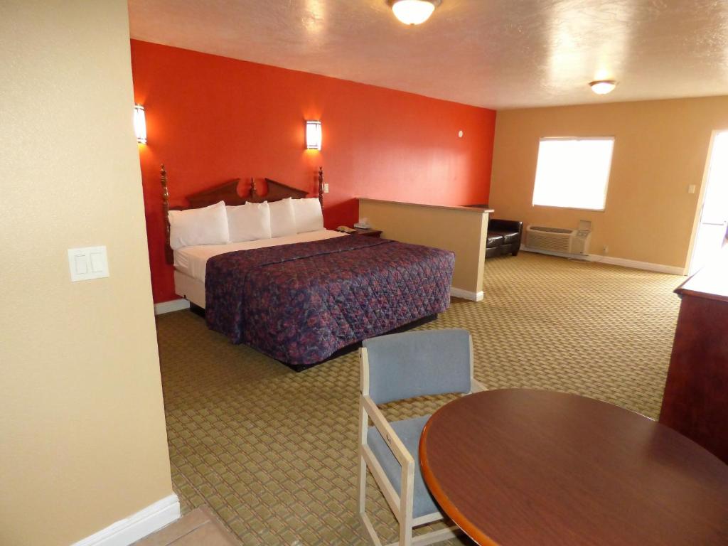 a hotel room with a bed and a table at Economy Inn & Suites in St. George