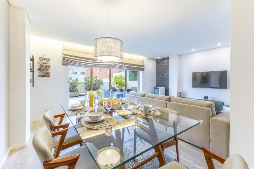 a dining room with a glass table and chairs at Tide Terrace Duplex by Portugal Active in Viana do Castelo