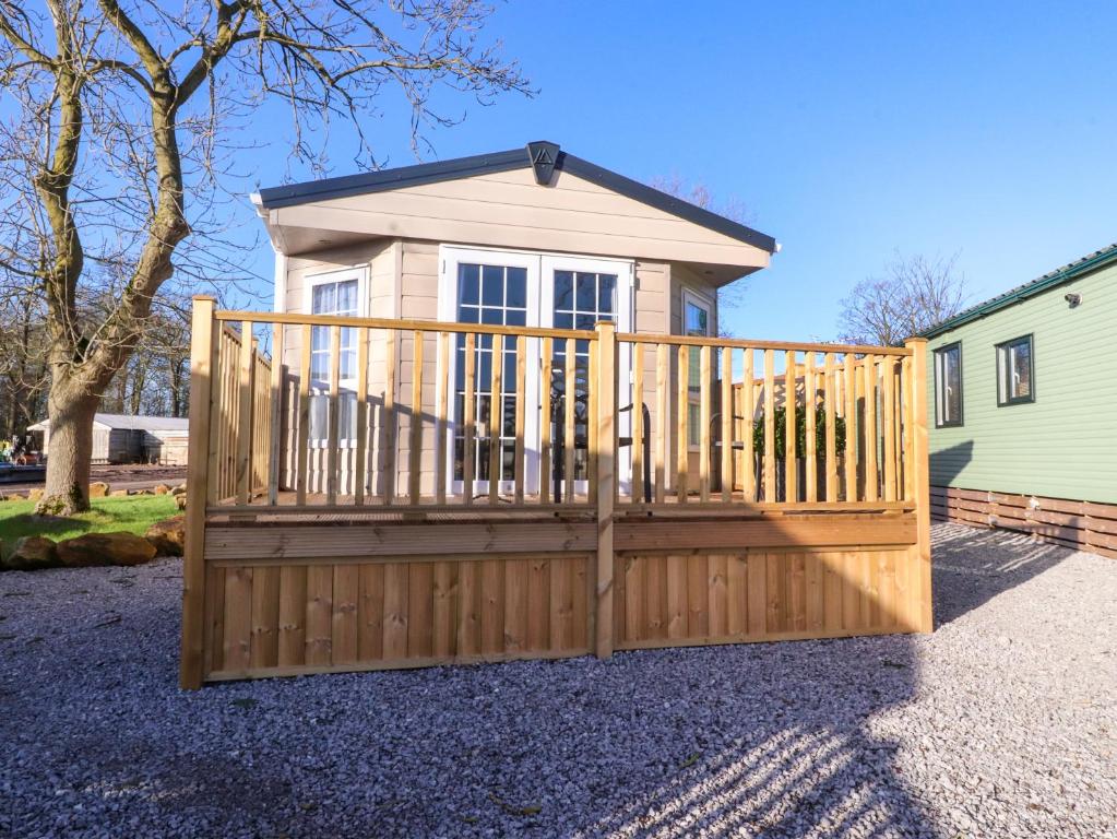 a wooden fence with a gate in front of a house at 17 Birchwood Close in Brown Moss Side