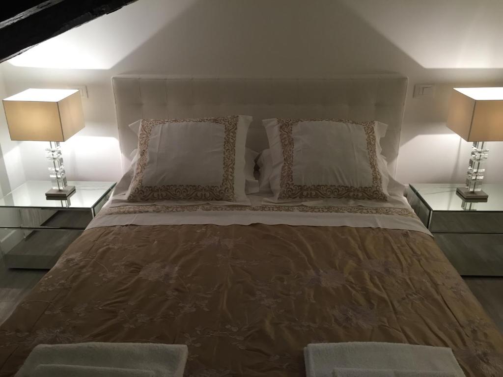 ボローニャにあるIn Un Borgo Nel Centro Storicoのベッドルーム1室(大型ベッド1台、ランプ2つ付)