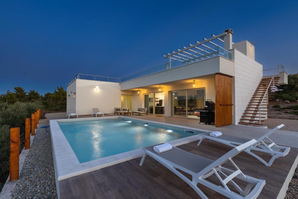 a villa with a swimming pool and a house at Villa Santa Lucia ZadarVillas in Turanj