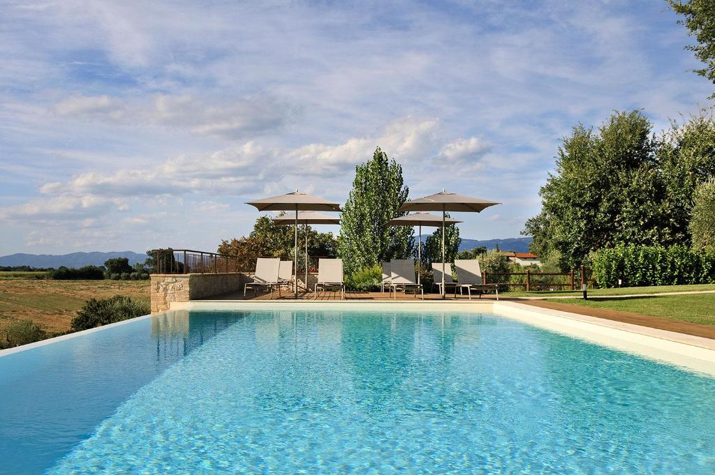 a swimming pool with chairs and a gazebo at AD MY HOME in Cortona