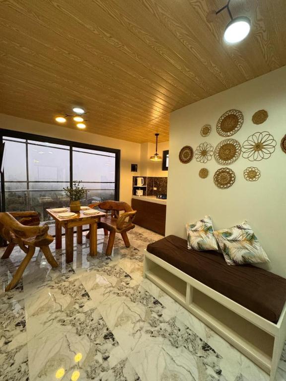 a living room with a bed and a table at Mountain Sunctuary-TD Solo Unit for friends and family in Baguio