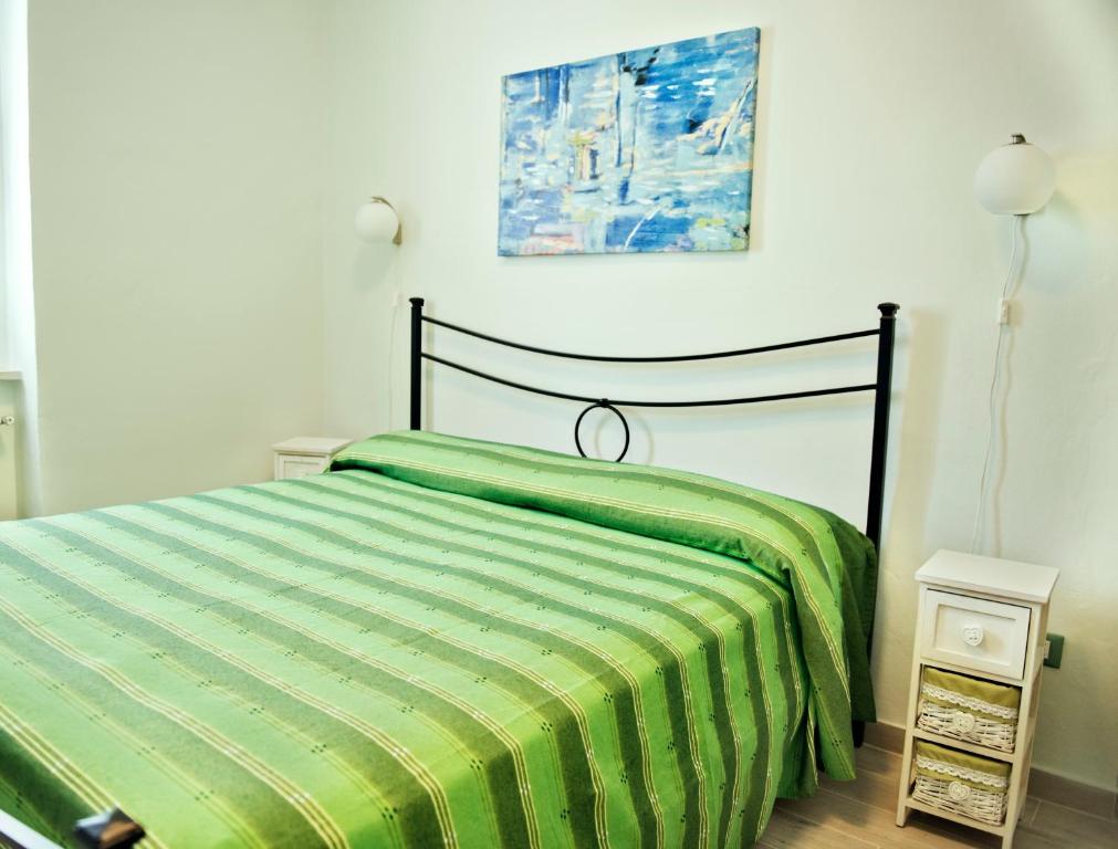 a bedroom with a bed with a green comforter at Azzurromare in San Vito Chietino