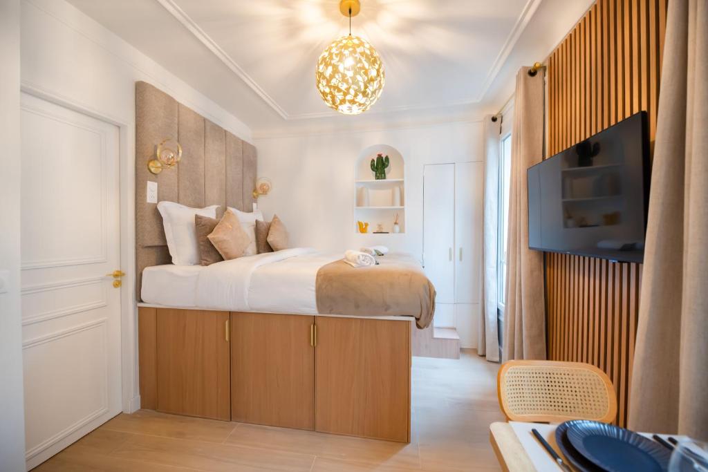 - une chambre avec un grand lit et une télévision dans l'établissement CIA - Studio de l'Étoile, à Paris