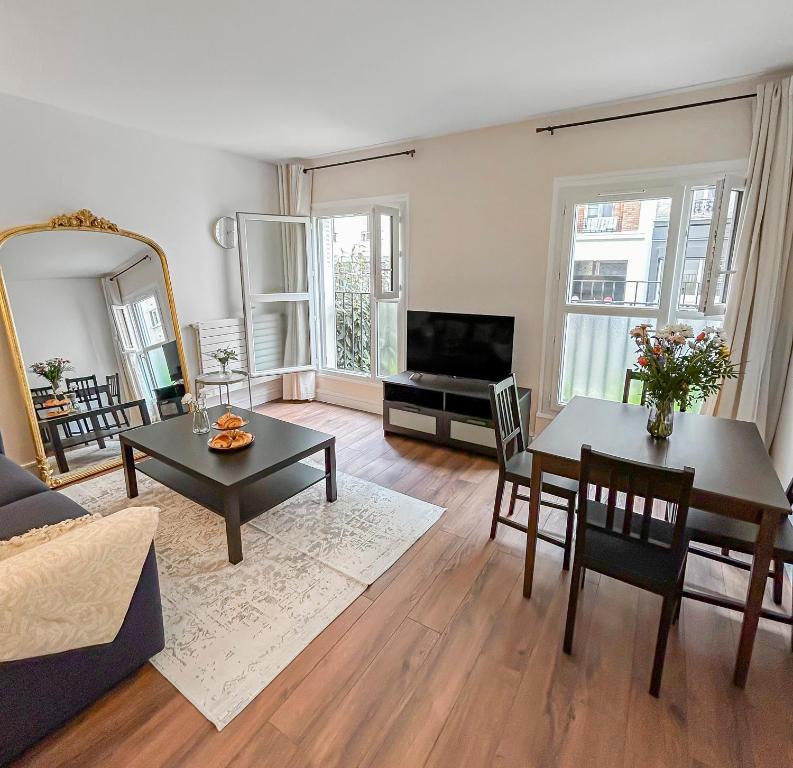 un salon avec une table et une télévision dans l'établissement L'écrin d'Ivry, à Ivry-sur-Seine