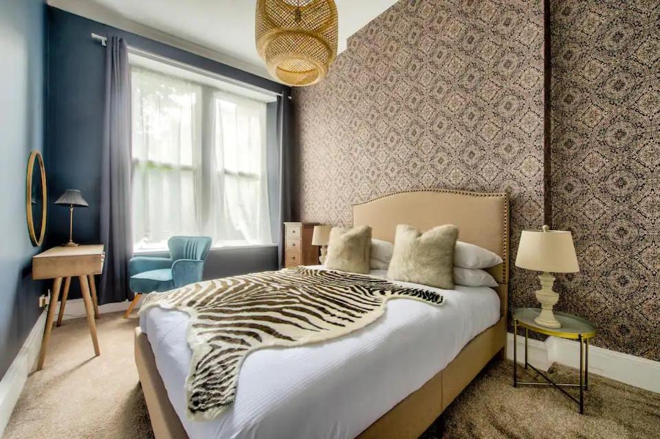a bedroom with a zebra print bed and a window at West End Holiday Homes in Glasgow