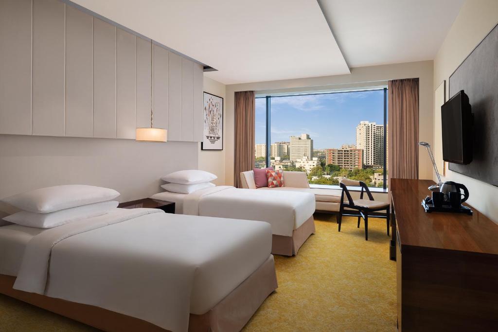 Postel nebo postele na pokoji v ubytování Renaissance Ahmedabad Hotel