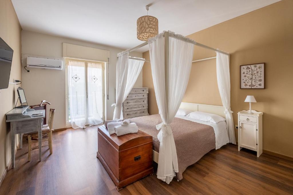 una camera da letto con letto a baldacchino e scrivania di Dimora Lorè a Polignano a Mare