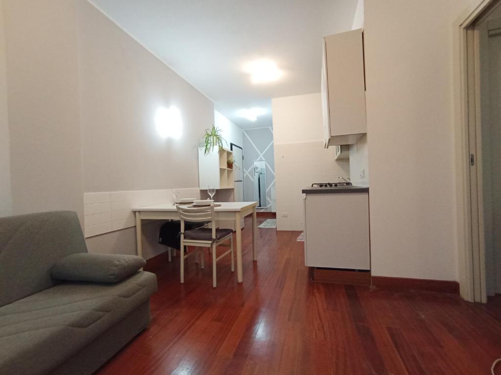 een woonkamer met een bank en een tafel en een keuken bij A casa di A in Milaan