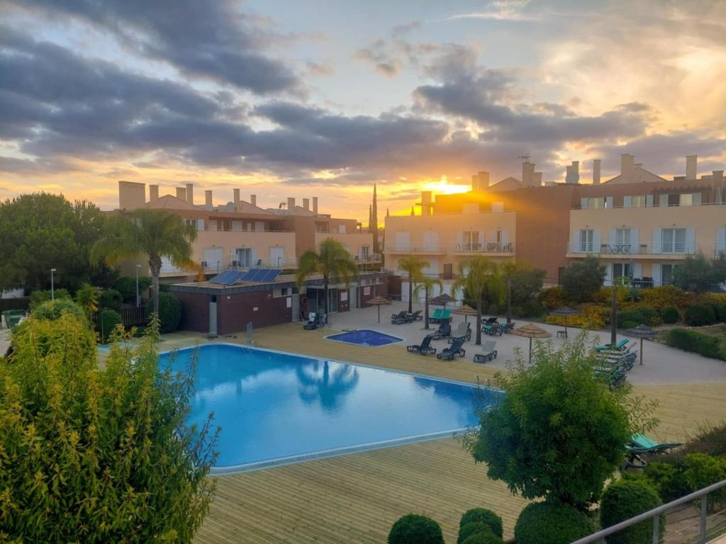 a view of a swimming pool in a resort at Casa Cabanas - Cabanas Gardens in Cabanas de Tavira