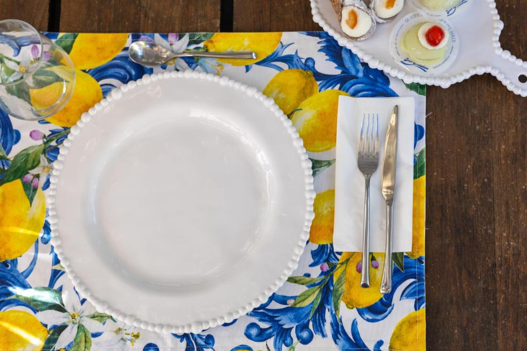 a white plate on a table with a table cloth at Villa Olimpia in Mondello